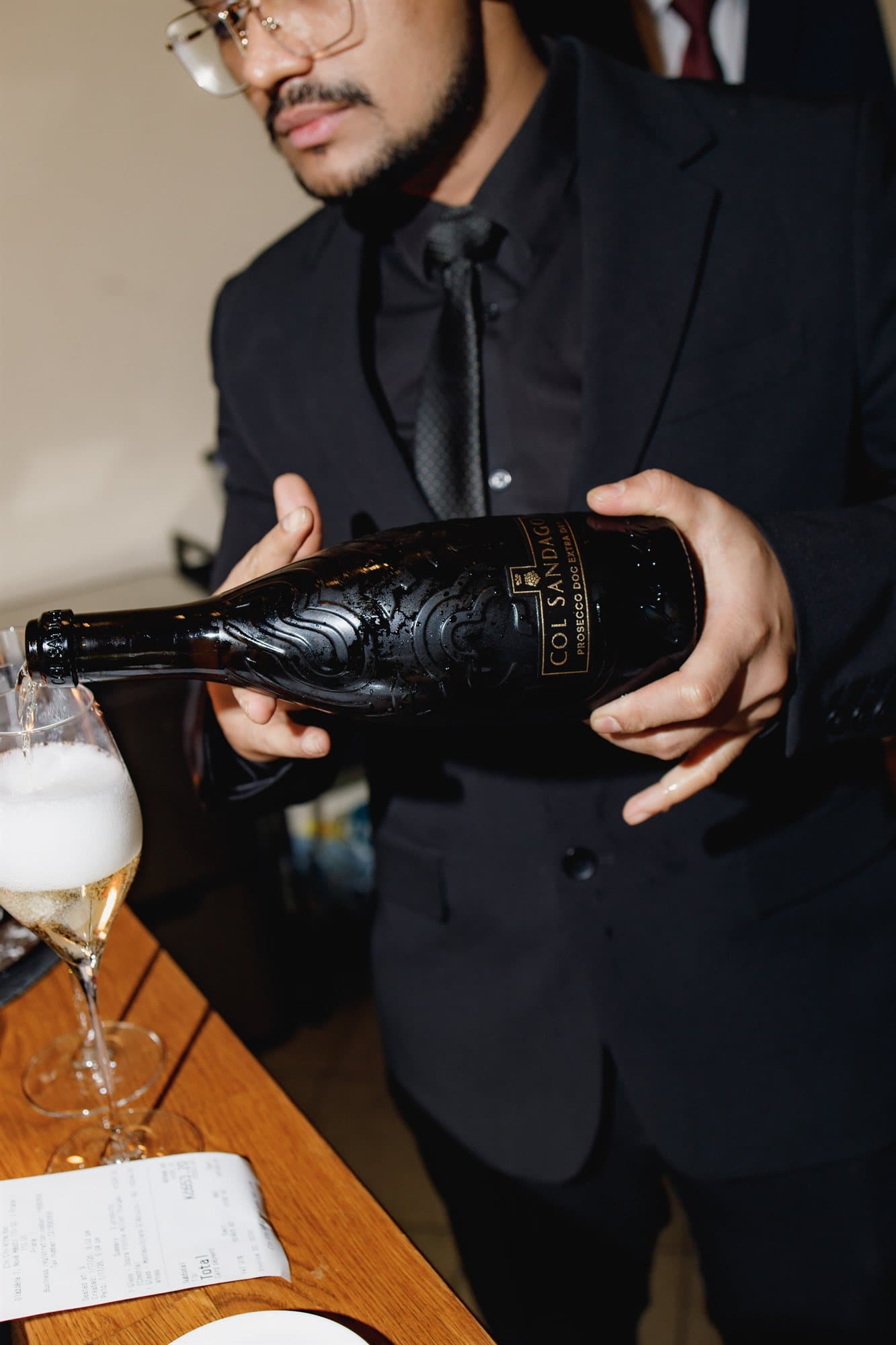 The sommelier pouring a glass of sparkling wine